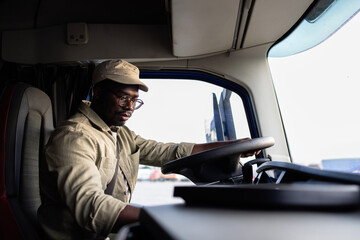 Fototapeta premium Professional driver sitting in truck cabin and driving.