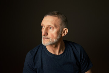 portrait of a handsome elderly man with a beard on a black background, close-up, selective focus