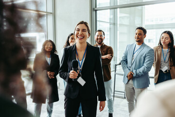Successful businesswoman giving a speech to a diverse group of colleagues in an office setting
