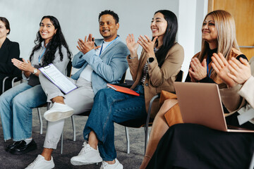 Engaged coworkers clapping during a corporate event
