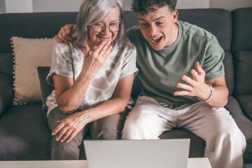 Enthusiastic generations  family fans watching football championship or olympic games on laptop...