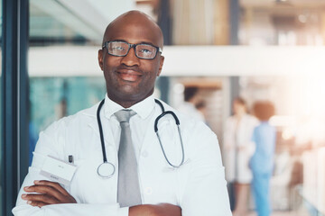 Doctor, portrait and confidence of black man for healthcare, wellness or medical experience with stethoscope. Hospital, smile and pride in health facility with crossed arms for cardiology or medicine