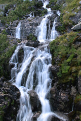 Vertical photo of the silky waterfall on the Transfagarasan mountain road in Romania