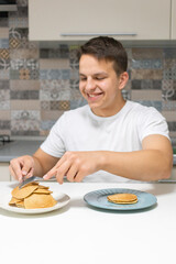 A young man eating in the kitchen.