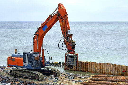 Pile driving machine on the beach on the seashore. Shoreline stabilization works