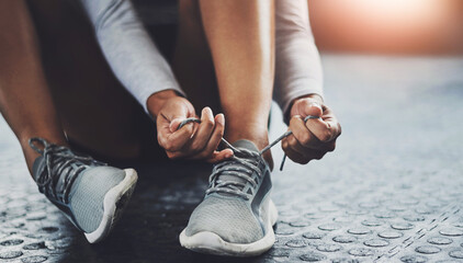 Gym, hands and person tie shoes to start exercise, training or workout at health club closeup on...
