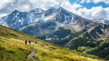 Fototapeta premium A view of a mountain range with hikers on a trail, capturing the beauty and challenge of mountain climbing.