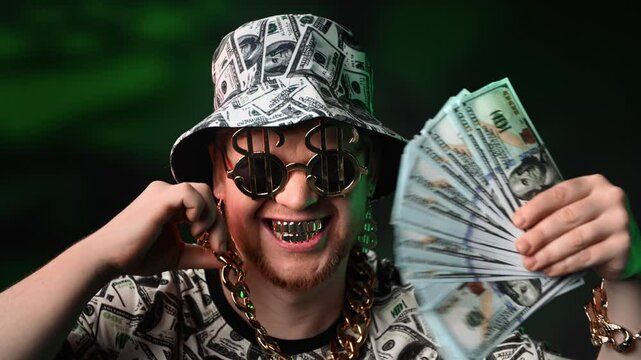 Rich man bragging about wealth showing his money and gold to camera, portrait of crazy millionaire