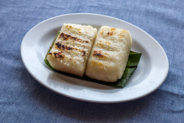 Ulen Traditional Food from Lembang, Indonesia, Grilled Sticky Rice, Coconut Flakes, and Peanut Sauce