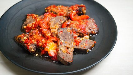 Lung beef (paru balado) cooked in spicy balado seasoning, which is sure to arouse appetite, selective focus and close up