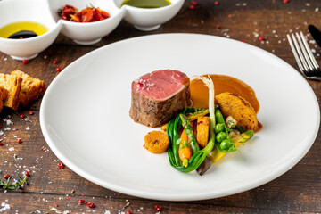 Filet mignon served with vegetables and sauces at a fine dining restaurant