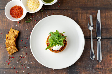 Italian dish Tortino di Verdure served on a white plate on wooden table