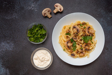 Mushroom Spaghetti Pasta and cream sauce on rustic, dark background, top view, copy space. Homemade italian pasta with champignon mushroom. 