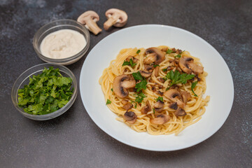Mushroom Spaghetti Pasta and cream sauce on rustic, dark background, top view, copy space. Homemade italian pasta with champignon mushroom. 