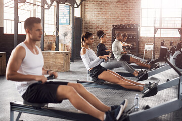 Fitness, gym and athletes on rowing machine for health, wellness and body workout with class....