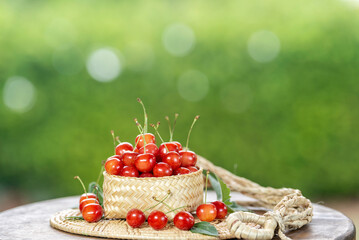 Red Cherry fruit on blurred greenery background.