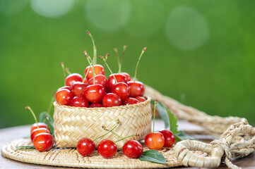 Red Cherry fruit on blurred greenery background.