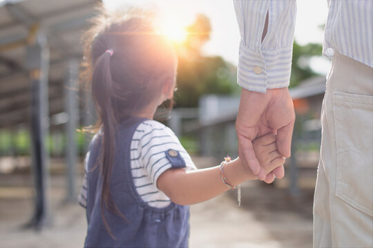 Father and daughter on a solar farm filled with solar panels. Solar energy for future generations Resource saving concept Electrical energy sources and alternative energy.