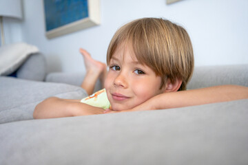 Cute caucasian child boy boy lying on couch