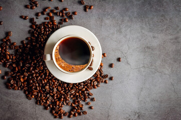 Overhead view of black coffee cup aromatic . Coffee cup and coffee beans on  gray background