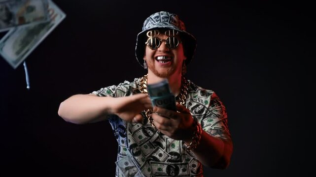 Happy rich man throwing money, portrait in studio, slow motion, flying 100 dollars banknotes in air