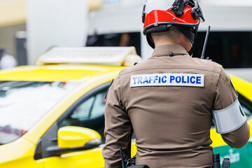 Thai traffic police officer working in busy road in Bangkok city metro operate solve traffic jam...