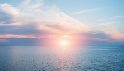 太陽が海の真ん中に沈みかけている。淡い水色と淡いピンクの空。