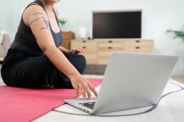Overweight Person Engaging in Home Workout for Wellness with Laptop Guidance