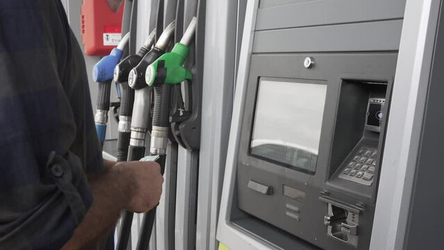 man paying for petrol at self-service petrol station