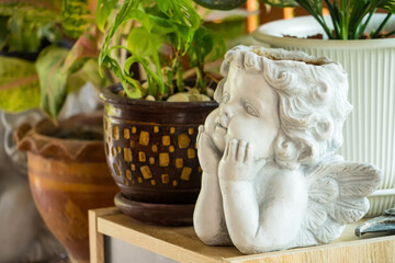 This picture shows a potted plant in the shape of a child resting his chin on his hand.