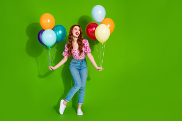 Photo of charming positive woman wear print top holding ballons bunch looking empty space isolated green color background