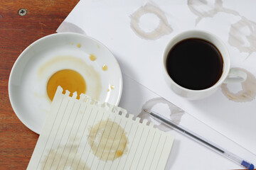 Spilled coffee and a blank sheet of notepad
