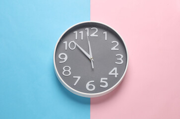 Large round wall clock on pink blue background