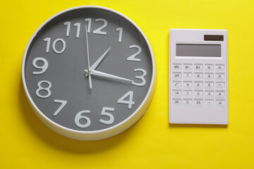Large round clock with calculator on yellow background.