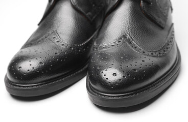 Stylish black leather men's brogue boots on a white background
