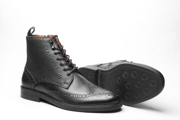 Stylish black leather men's brogue boots on a white background