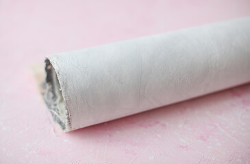 Roll of concrete photo backdrop on pink background