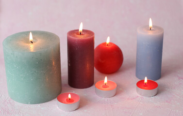 Flaming candles on a pink background. Romantic atmosphere