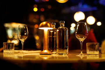 The water bottle and clear wine glass are waiting for the restaurant guests.