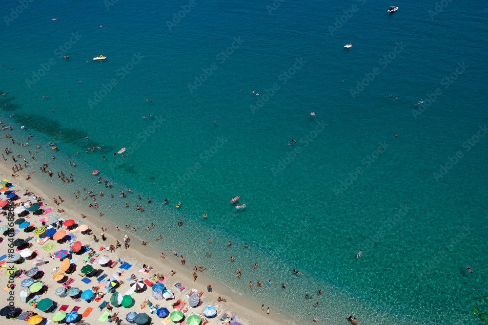 Wall mural aerial view of sandy beach with swimming people in sea with transparent blue water in summer.