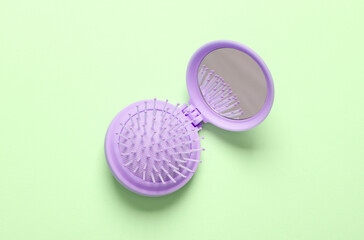 Mini mirror comb organizer on mint green background. Top view. Beauty concept