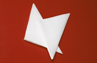 Naklejka premium White paper napkins on a red background. Top view
