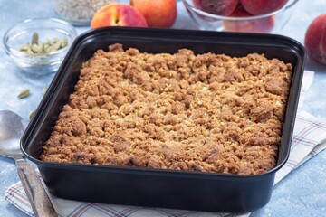 Delicious Peach Crisp or cobbler with brown sugar and oat streusel in backing dish, horizontal