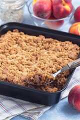 Peach Crisp or cobbler with brown sugar and oat streusel in backing dish, vertical