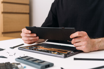 Technician repair laptop and remove, replace and recycle old battery on laptop