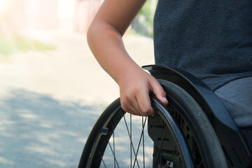 Obraz premium Boy's hand on the wheel of a wheelchair