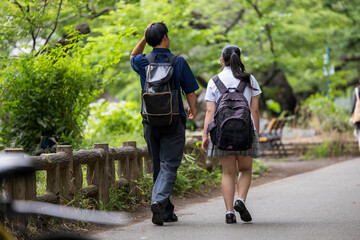 公園を歩く高校生男女