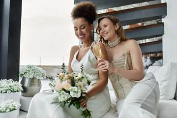 Two brides share a celebratory toast on their wedding day.