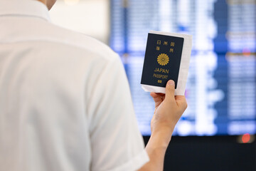 電光掲示板で出発時間を確認する男性