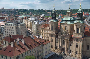 Fototapeta premium Tourists walking in the streets of Prague with a view on the st. Nicholas, Czech Republic